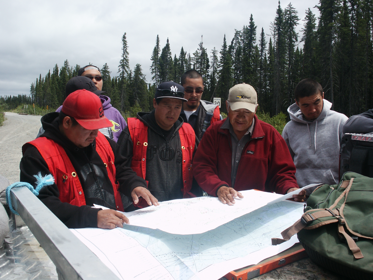 Sam Bosum reviewing a map with prospectors in the field